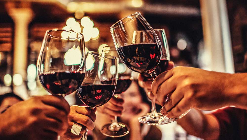groups cheersing red wine glasses